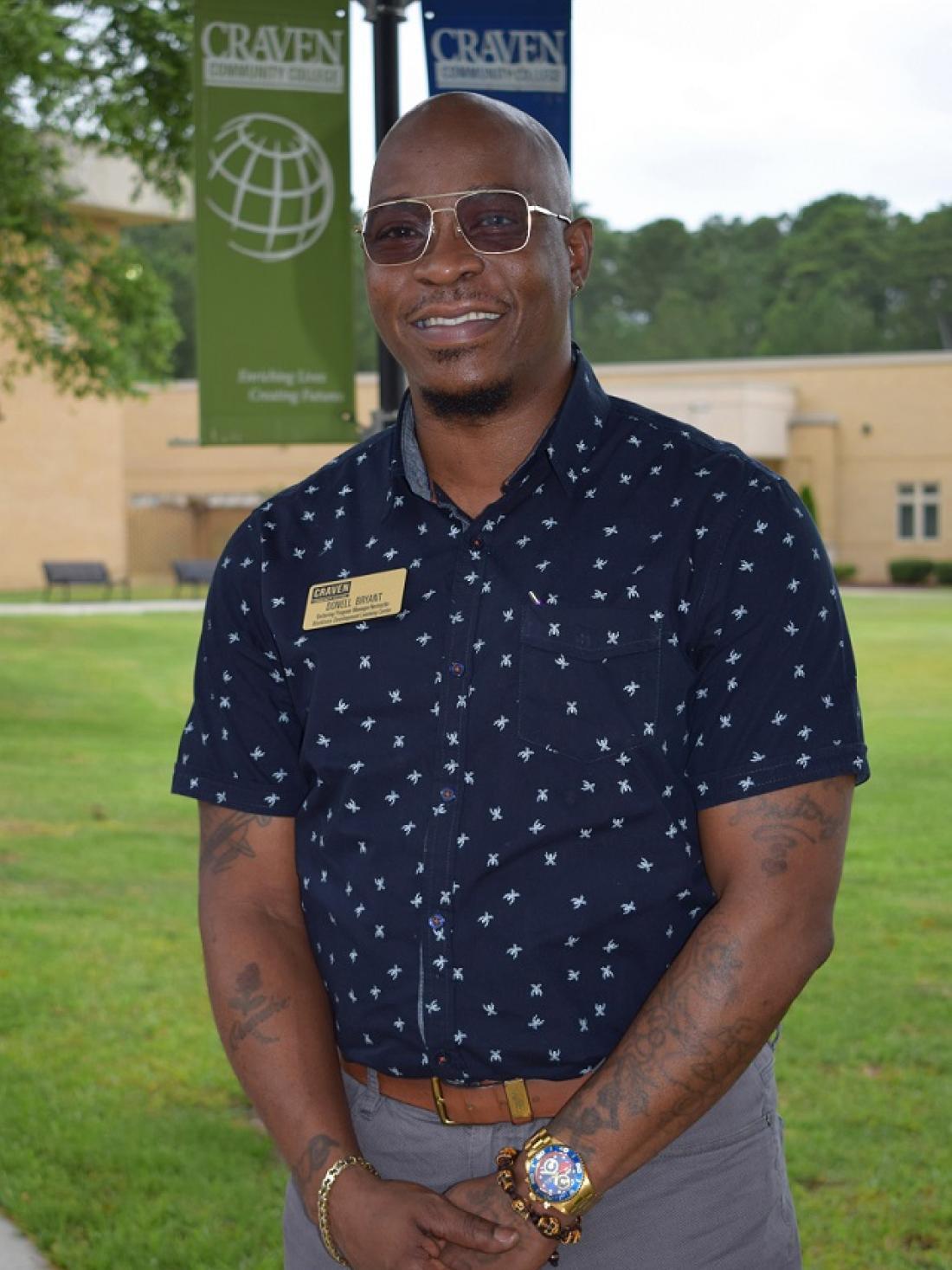 Barbering instructor Donell Bryant posing outside on campus