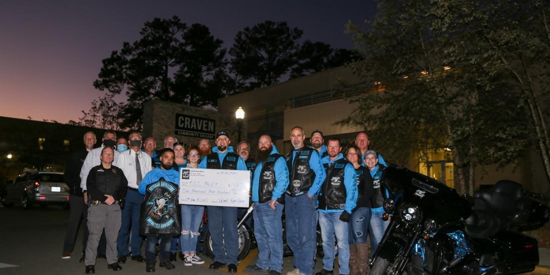 Veteran Enforcers Motorcycle Association of New Bern members on motorcycles deliver donation to college
