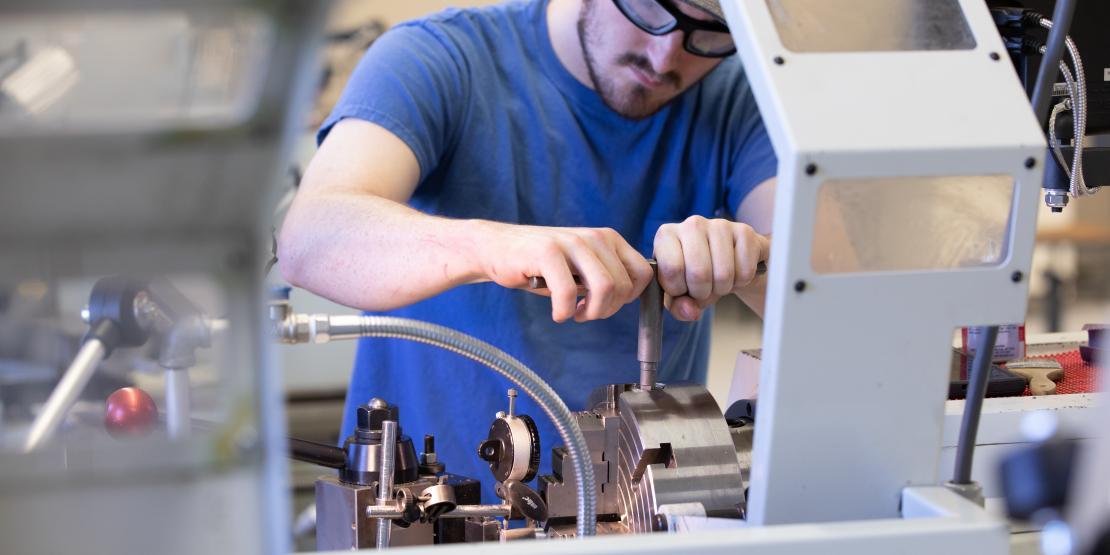 Male student uses a lathe