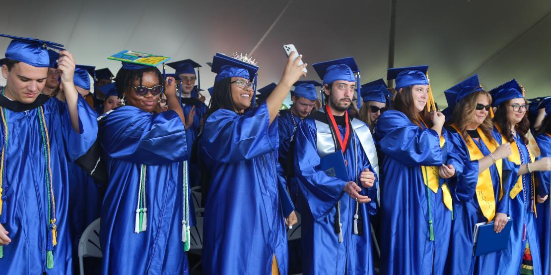 2023 graduates in caps and gowns moving tassel over