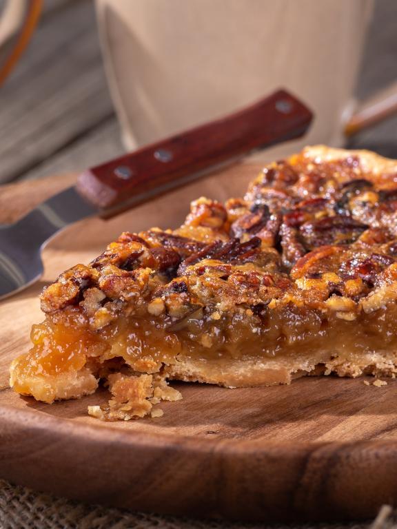 Slice of pecan pie on a plate with a fork