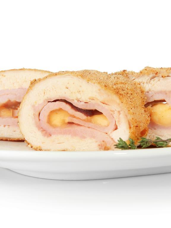A plate with three pieces of chicken cordon bleu and garnish