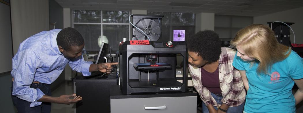 Students looking at 3-D printer