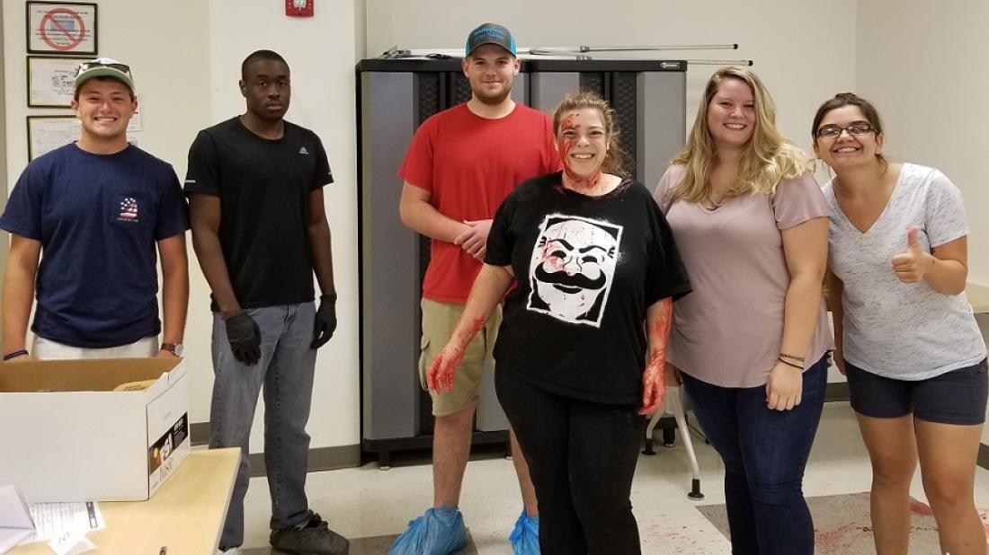 Craven CC Criminal Justice program students pose in a crime scene lab. Pictured left to right are Jeffrey Conner, Jamir Smoak, Nathan Rouse, “victim” Sandra Miller-Prince, Katie Hardy and Vic Shackley.