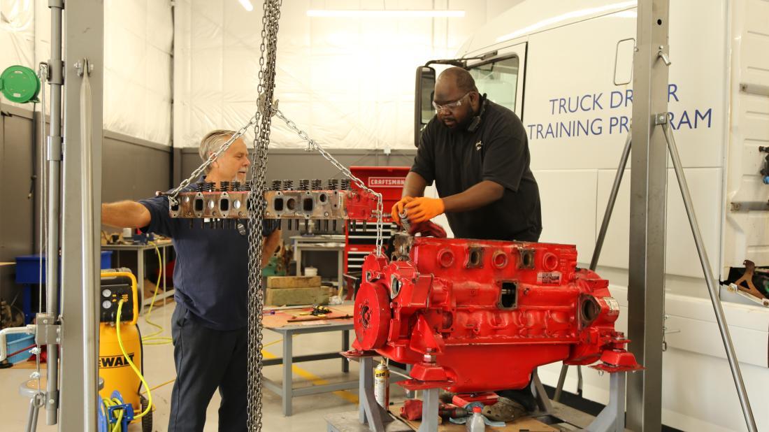 Diesel systems student works on parts in diesel garage