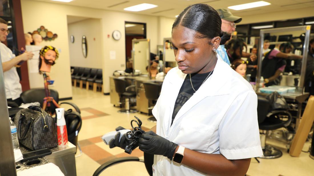 Female barbering student sets up her gear