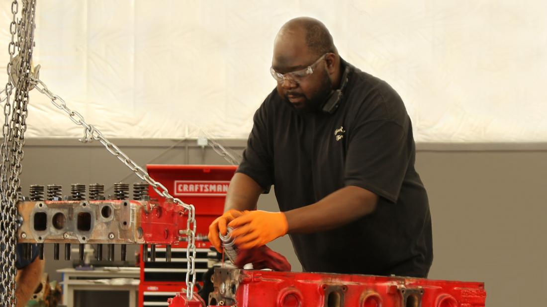 Male student works on red engine in Diesel Engines program