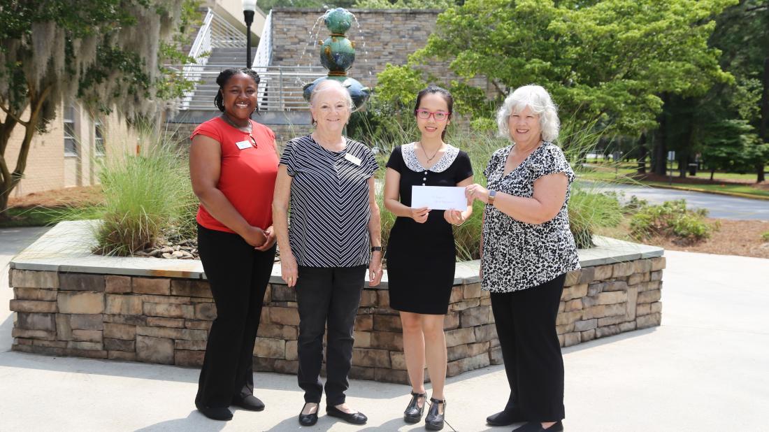 AAUW members present a check to student Vy Tran