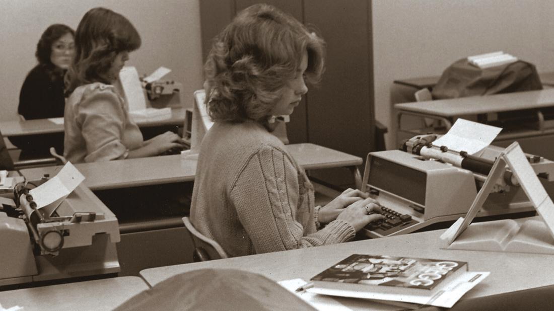 Female students typing on typewriters in 1980