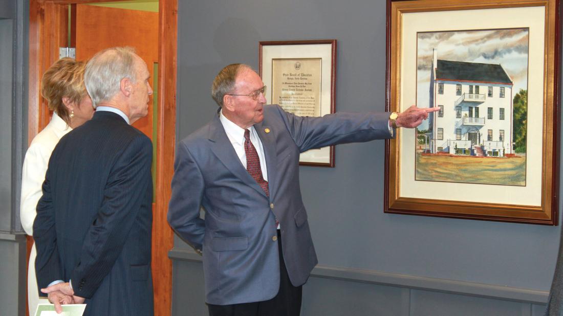 Dr. Brock points to Harvey Mansion painting in board room in 2011