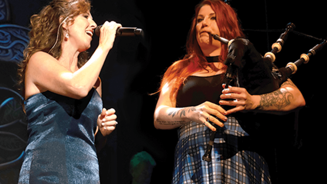 Two women signing and playing bagpipes