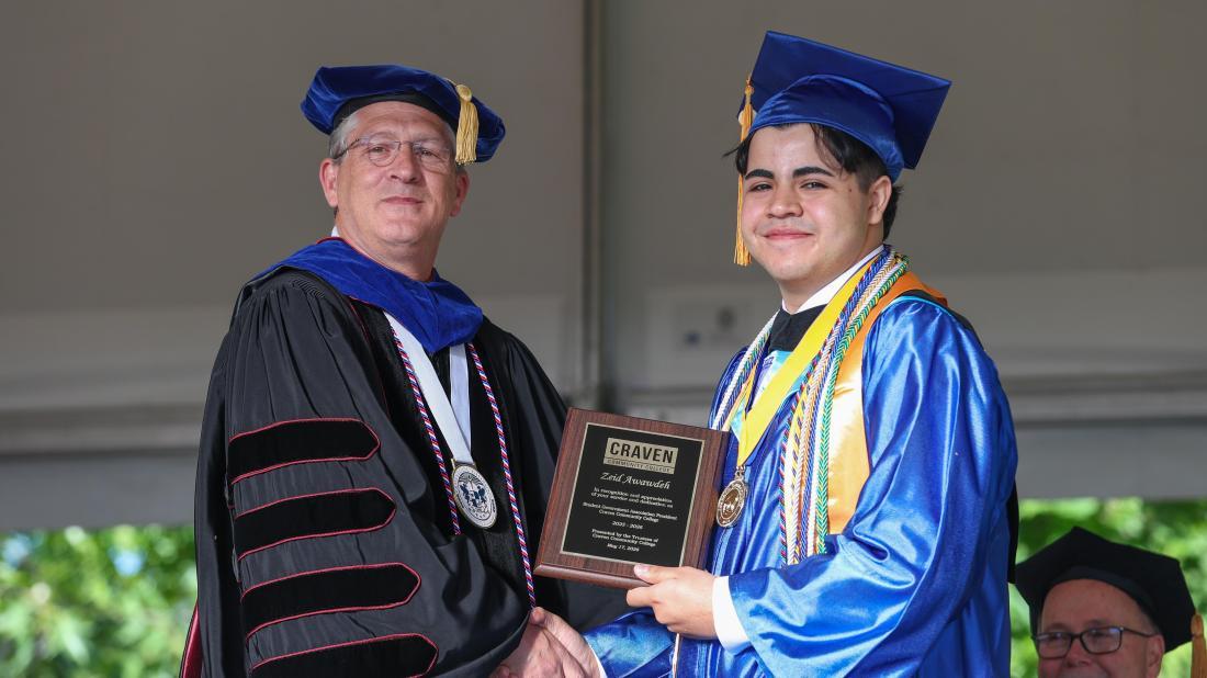 Student receives degree on stage at graduation
