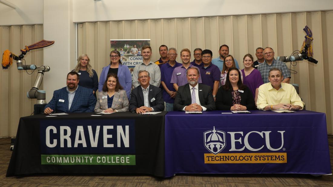 People sitting at a table with tablecloths for Craven and ECU