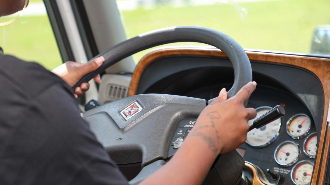 Transportation student practices driving a commercial vehicle during hands-on training.