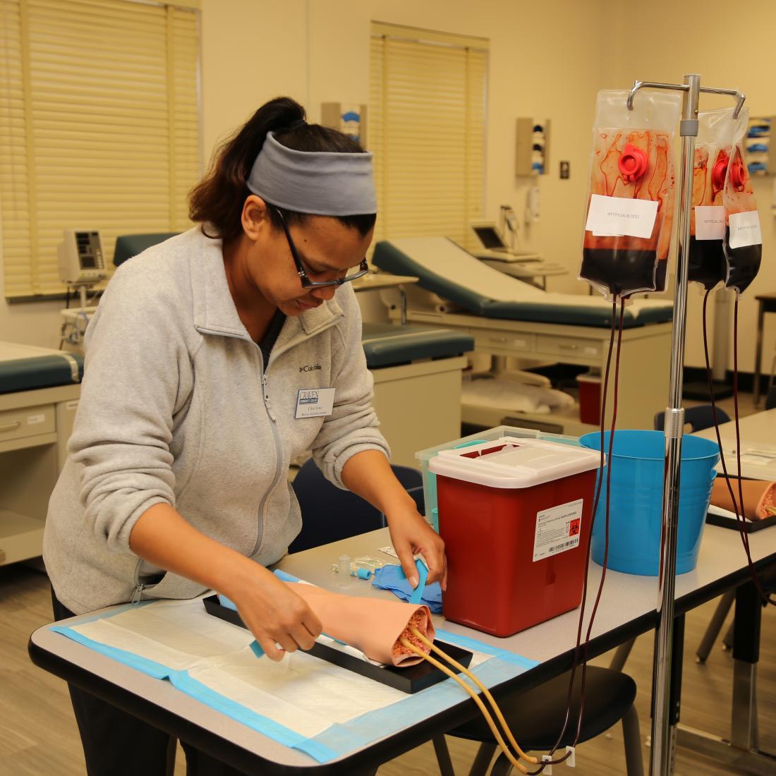 Medical Assisting student practices inserting needle on faux arm
