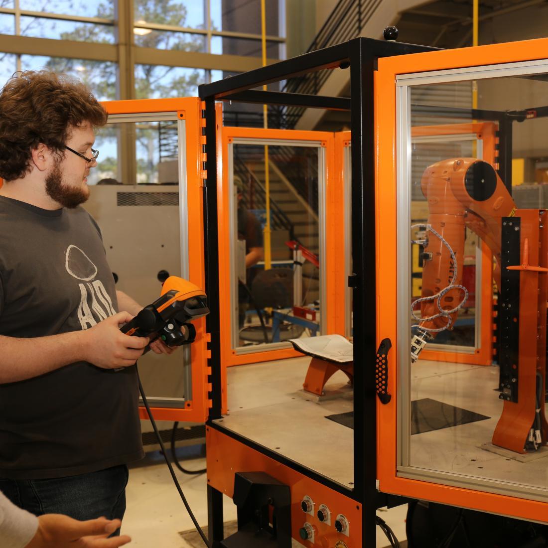 Two students look over computer-integrated machinery