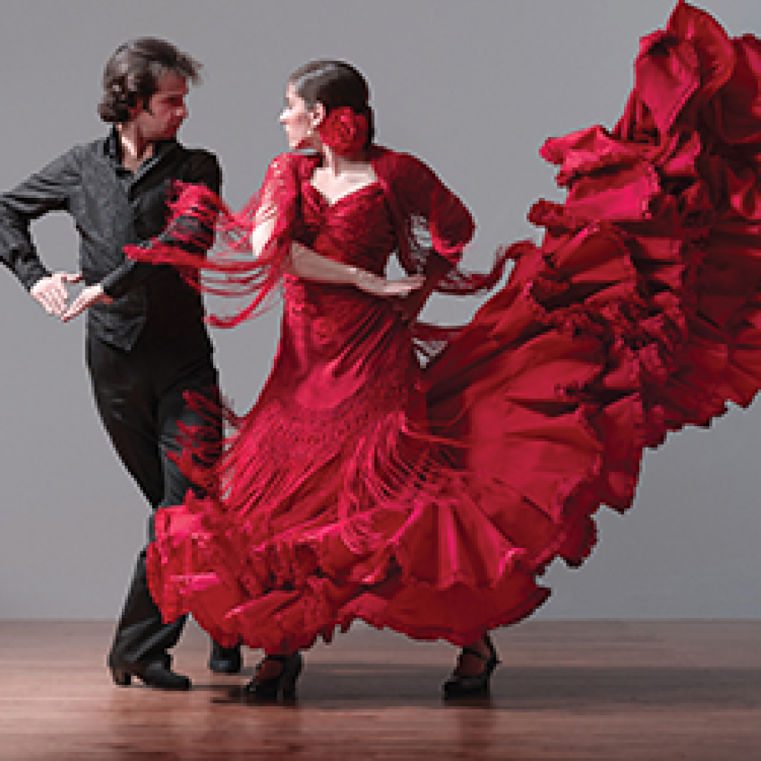 Spanish dancers, male in all black and female with elaborate red ruffled dress and red flower piece in hair