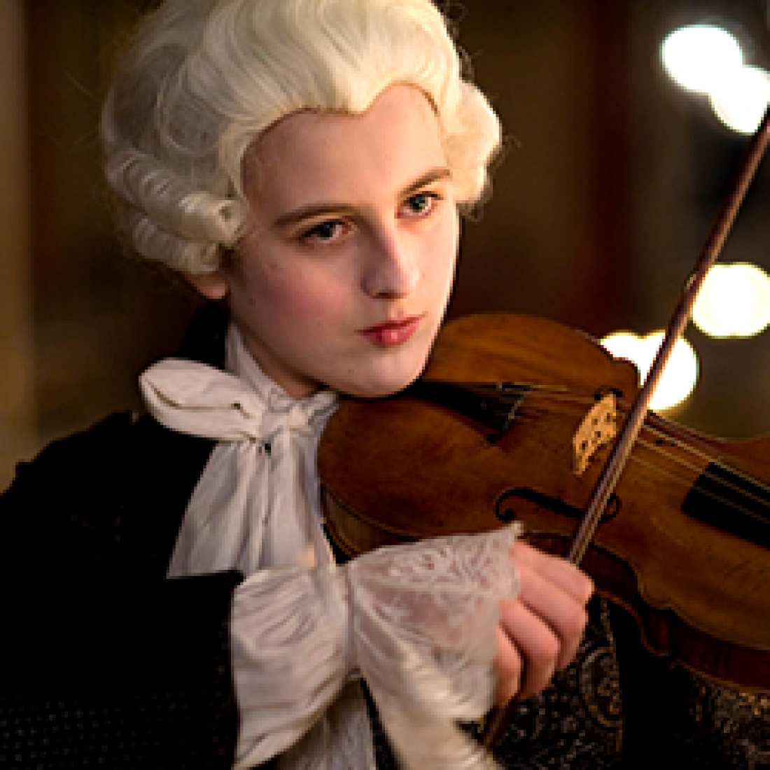 Still of Maria Anna in white period wig playing the violin from the film Mozart's sister