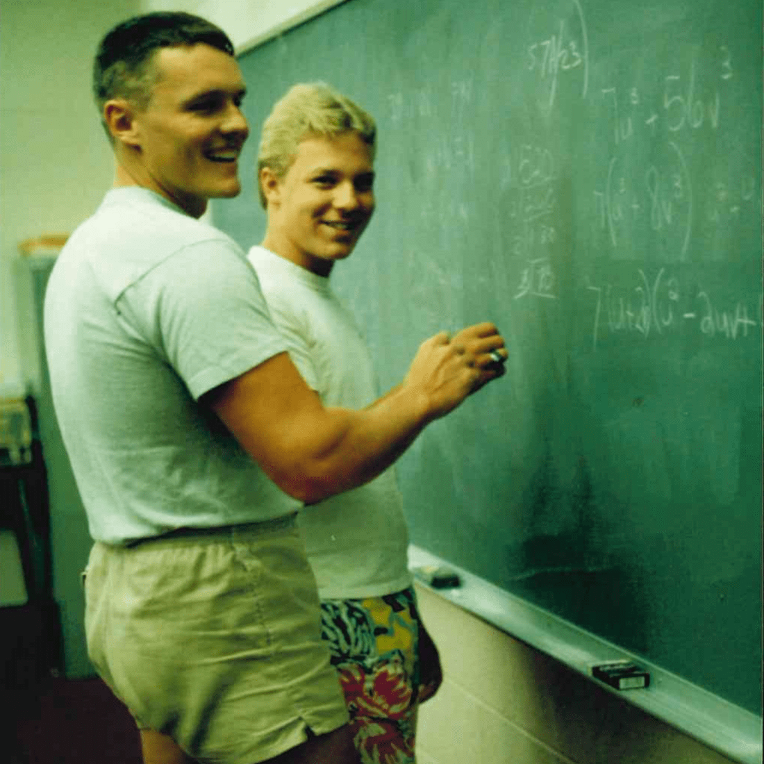 Two male students at a chalkboard in 1980s