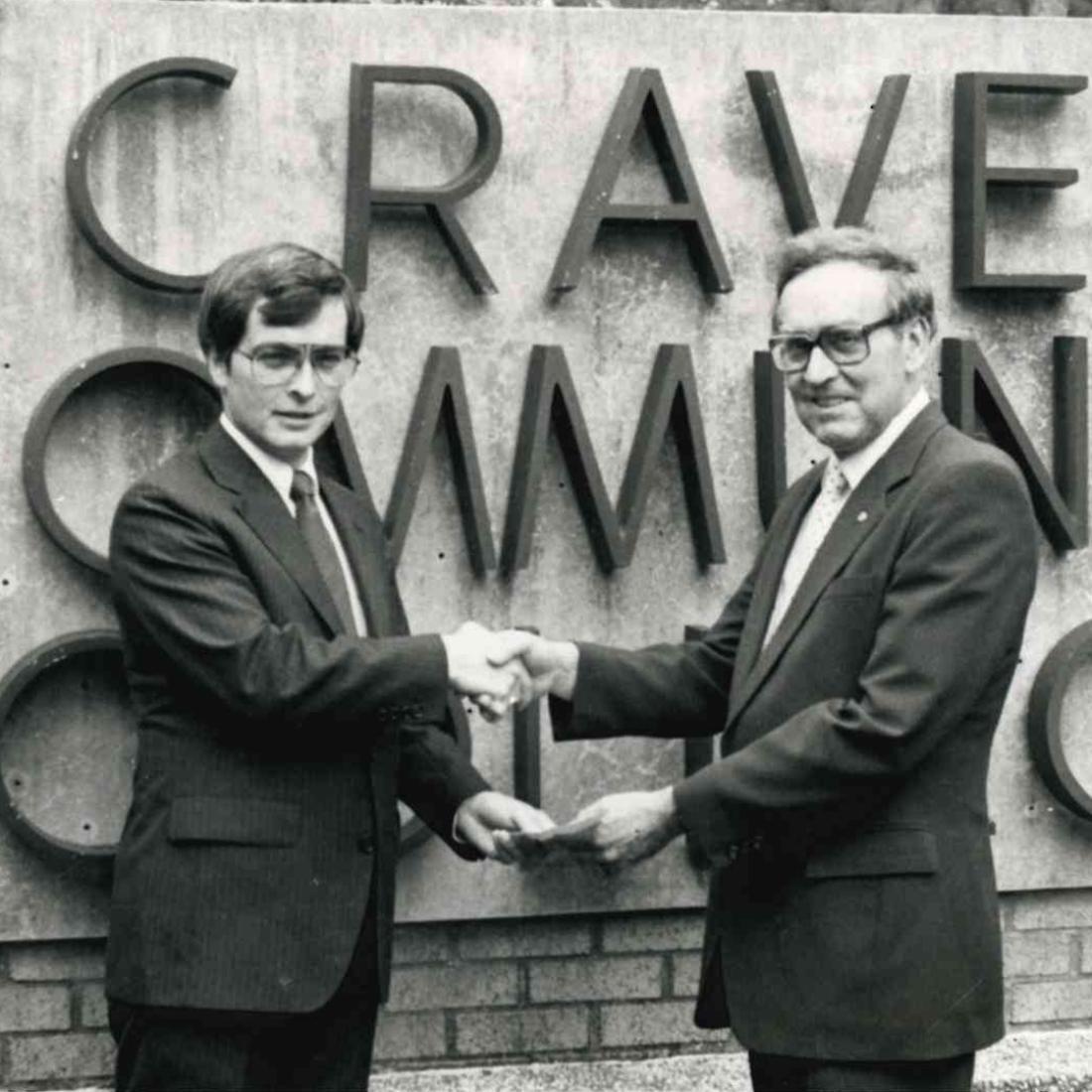 Male standing with Dr. Brock by Craven CC sign in 1988