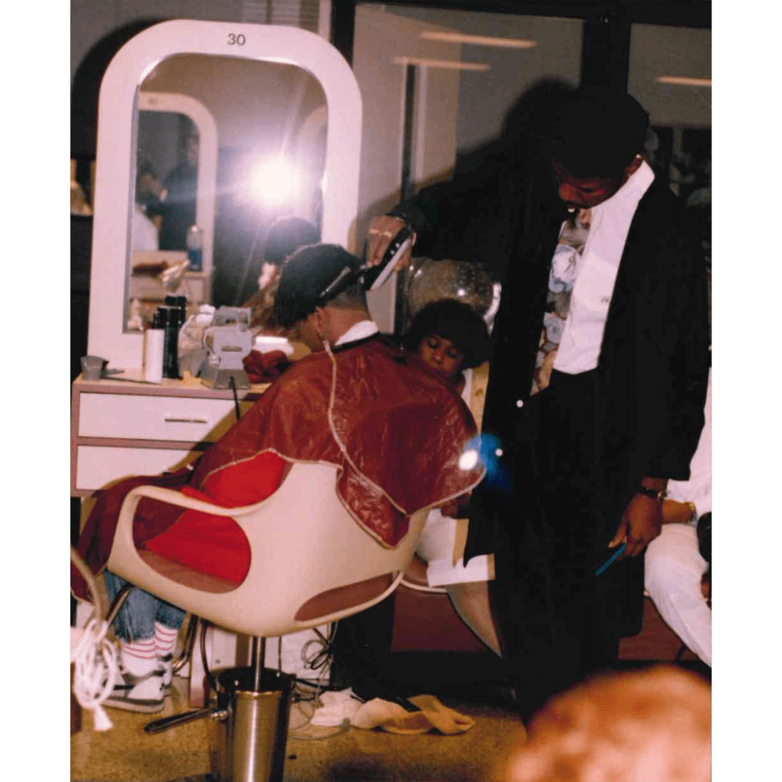 Barbering student cutting a customer's hair in 1991