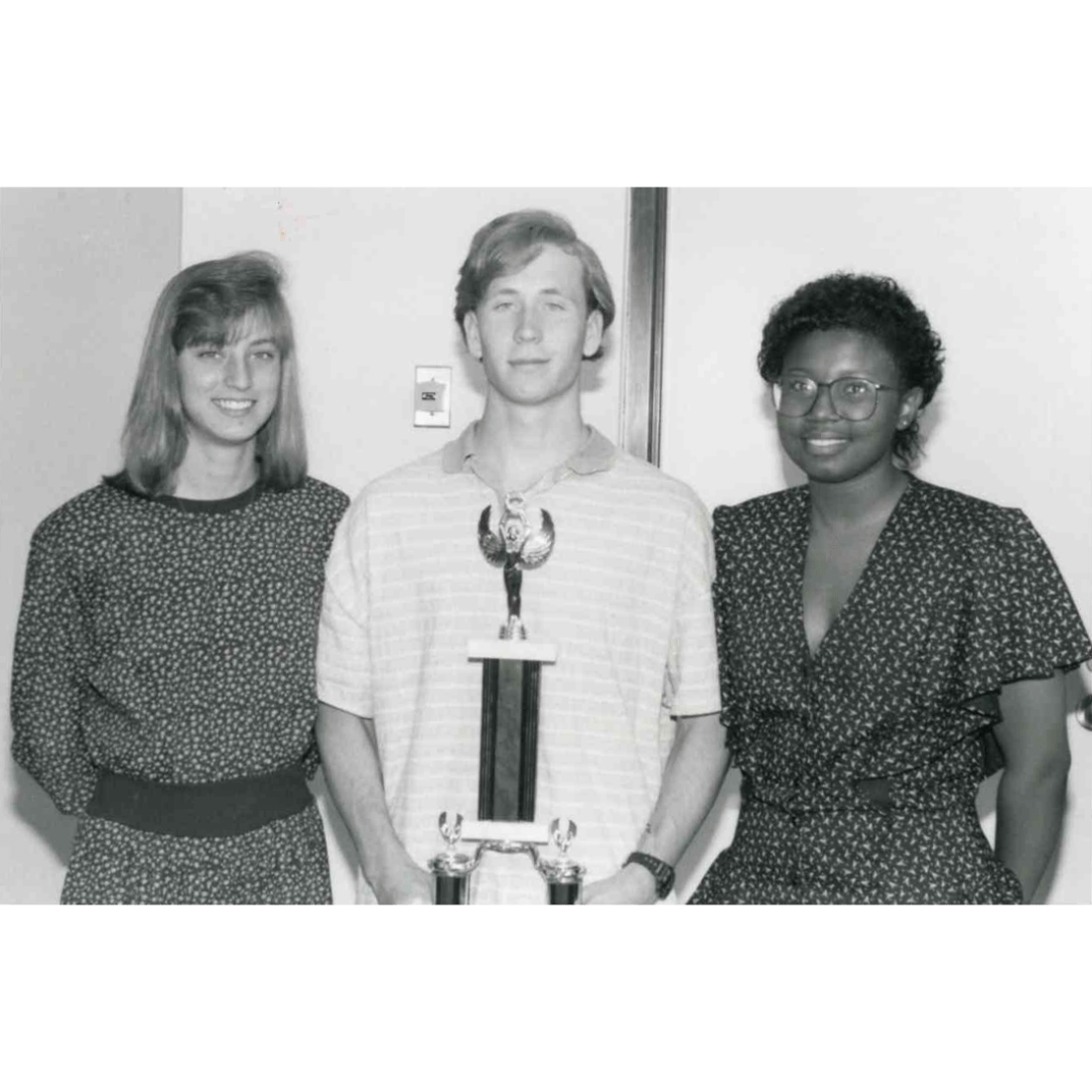 Three students with typing contest trophy in 1991