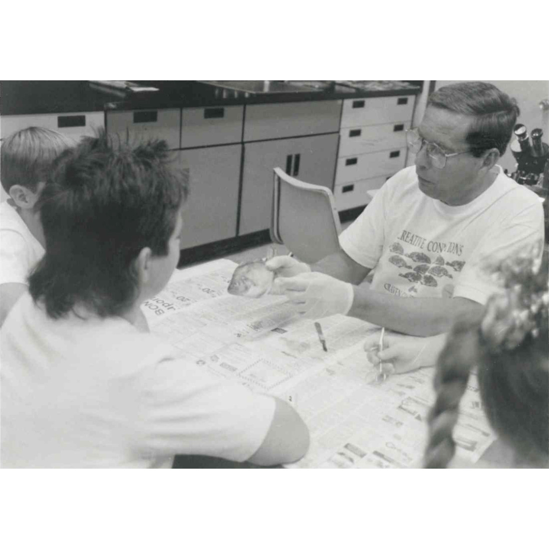 Students and instructor examining fish for biology class in 1992