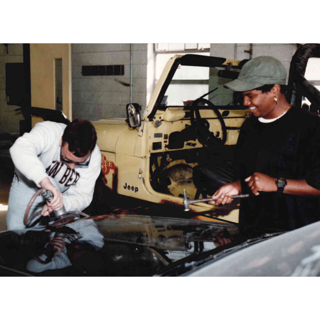 Two male automotive students work on a car in 1994