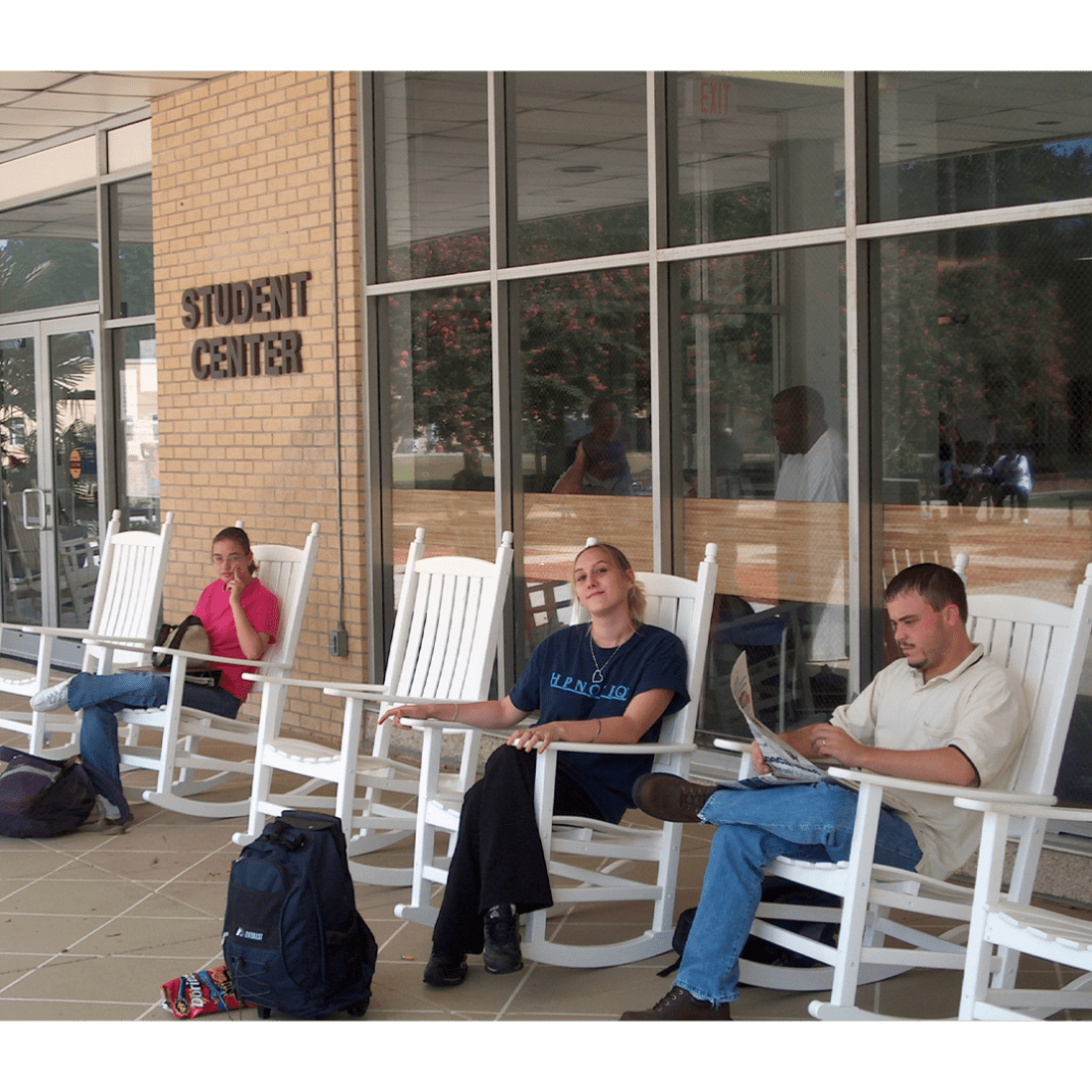 Students sitting in rocking chairs outside Student Center in 2000s