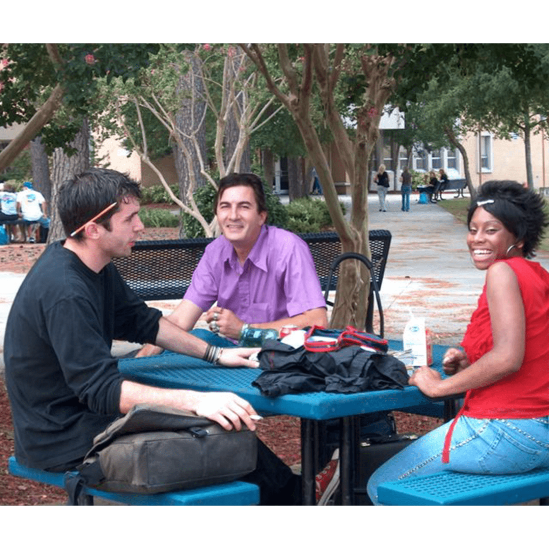 Three students sitting outside in mid-2000s