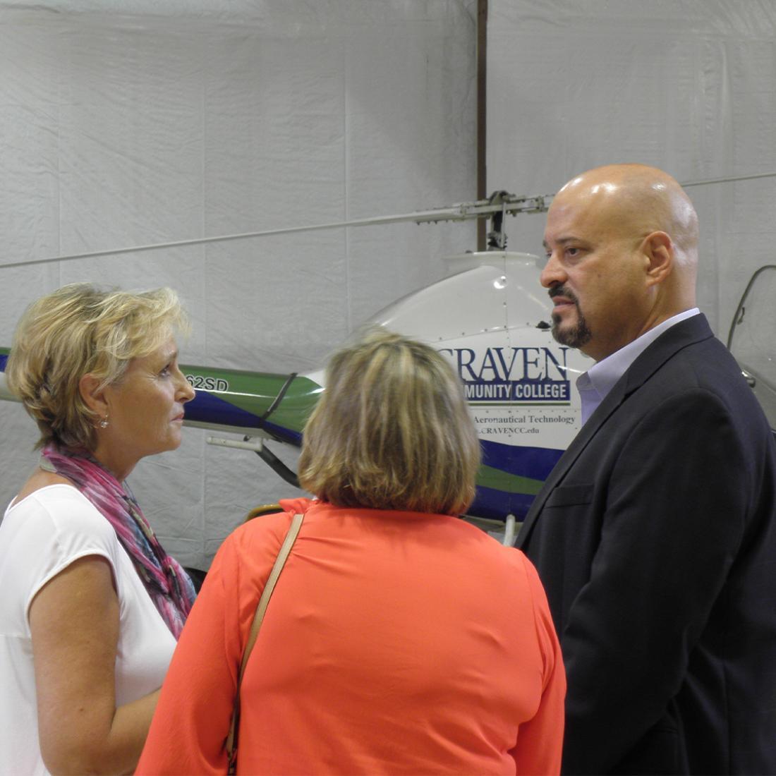 Dr. Catherine Chew speaking with stakeholders by branded helicopter on Havelock campus in 2010s