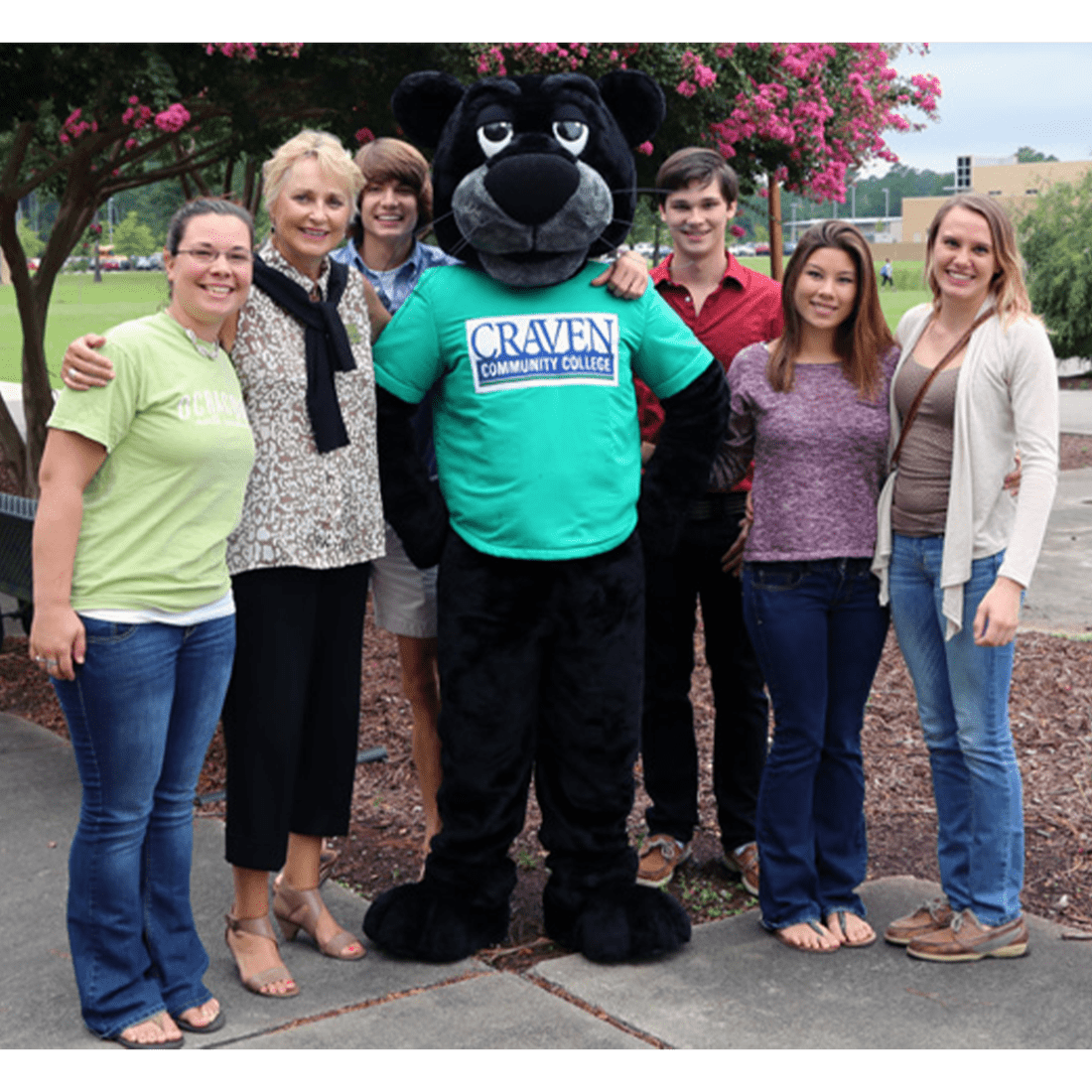 Dr. Catherine Chew with Knight the Panther mascot and students in 2010s