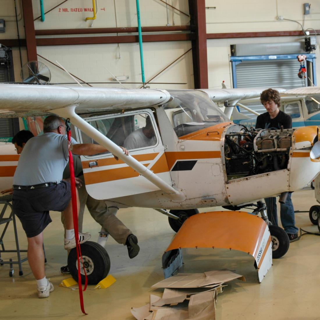 Instructor and students working on aircraft in 2010s