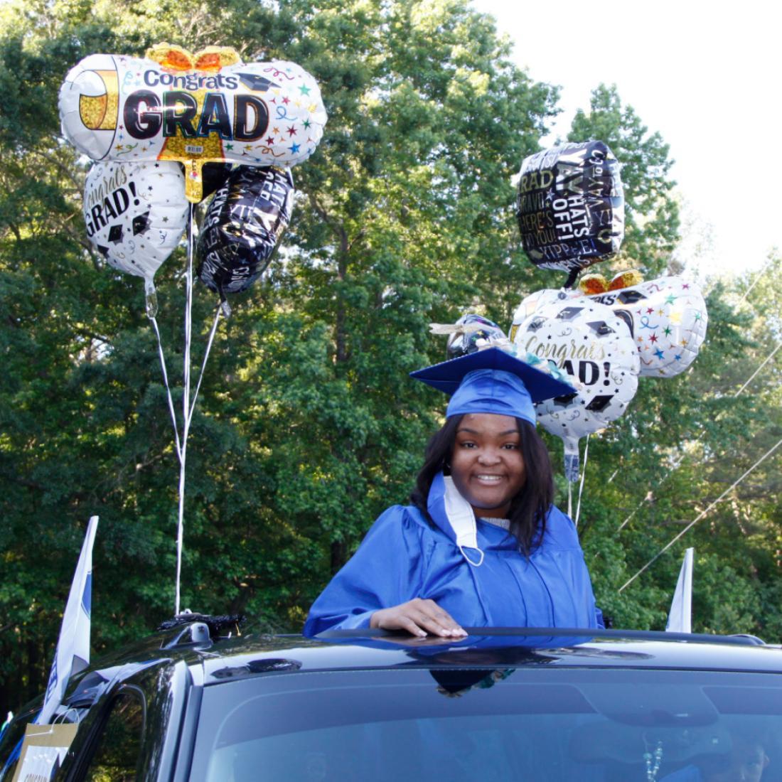 Female graduate participates in drive-thru graduation in 2021