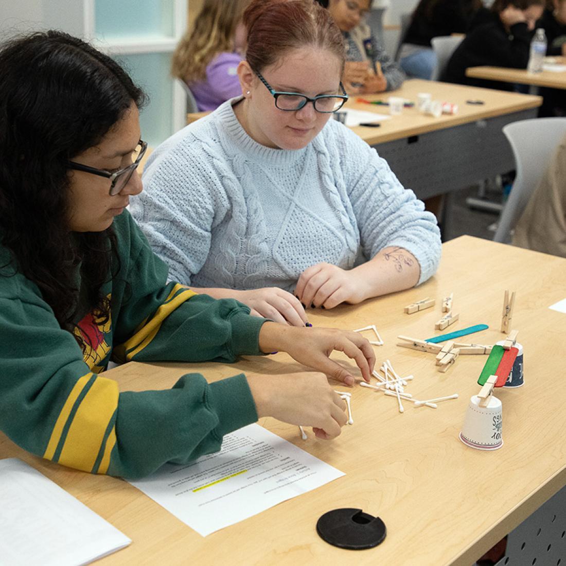 Students work with Q-tips during a STEM event