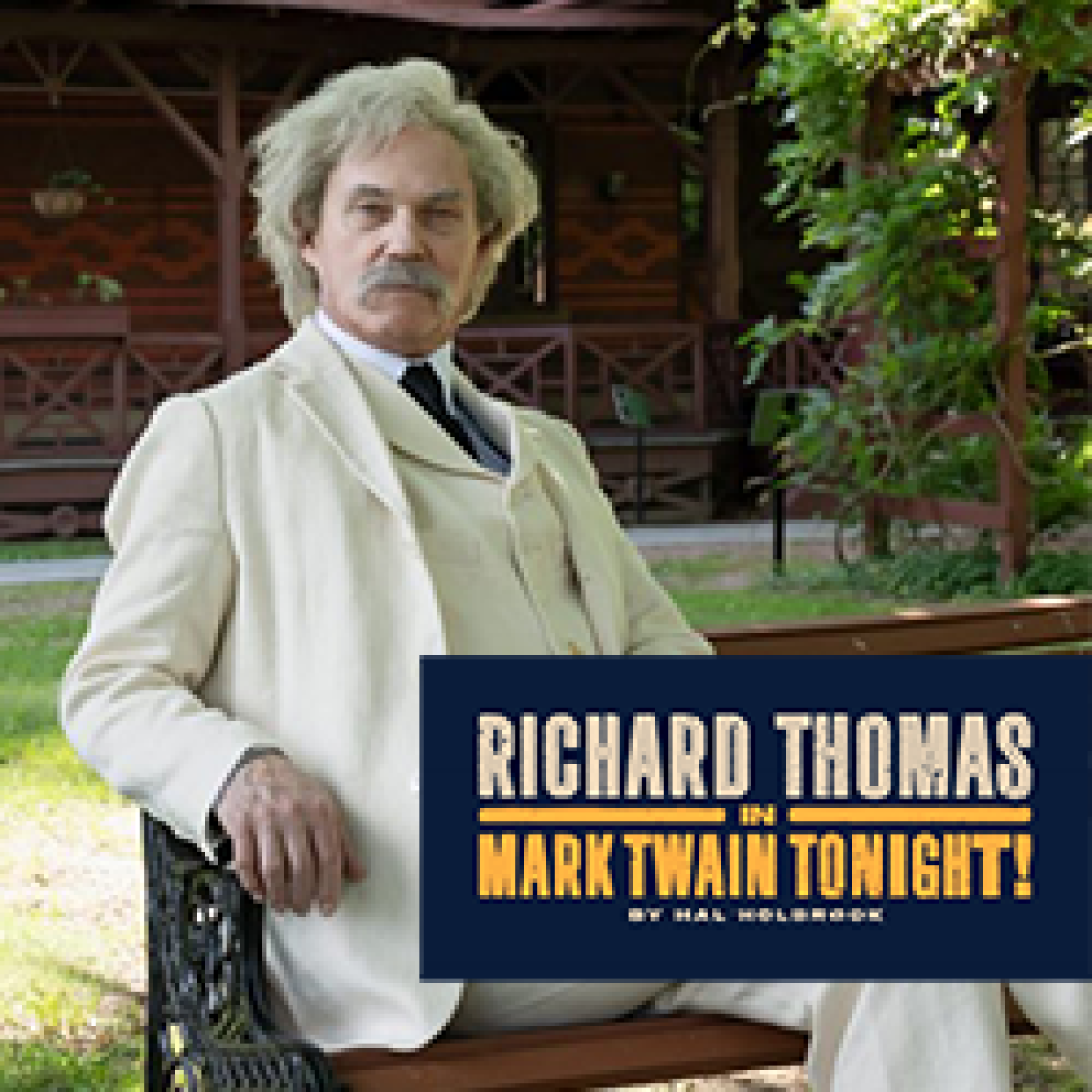 Richard Thomas dressed as Mark Twain sitting outside on a bench