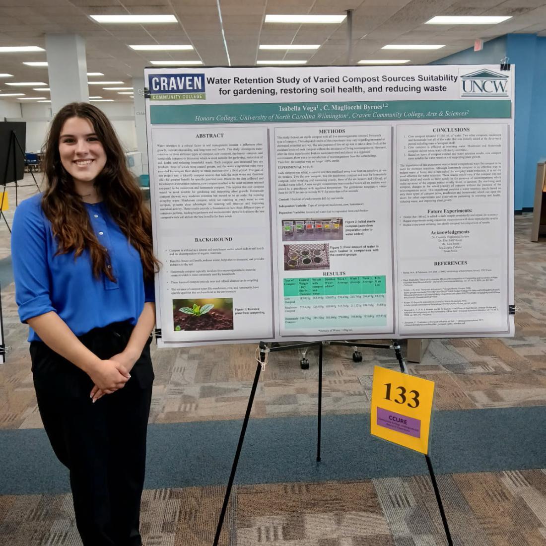 woman stands next to research poster 