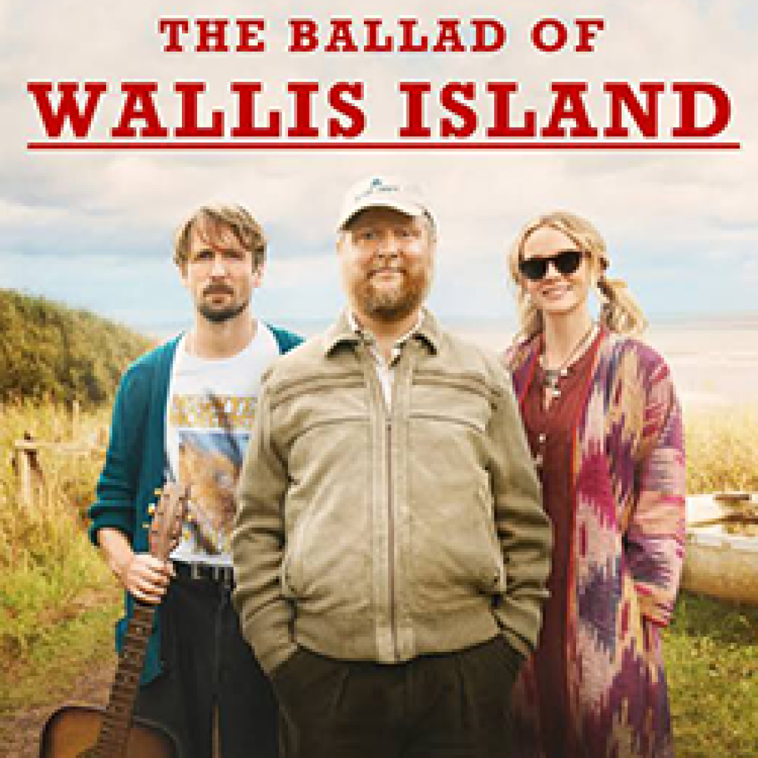 Promotional image for The Ballad of Wallis Island featuring three characters standing in a coastal landscape, with one holding an acoustic guitar.