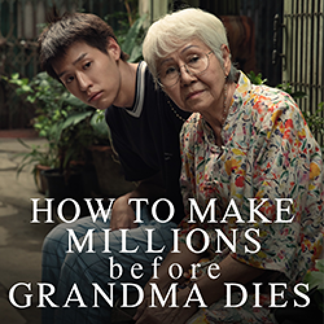 Young man leans beside an older woman wearing glasses and a floral shirt in a promotional image for How to Make Millions Before Grandma Dies.