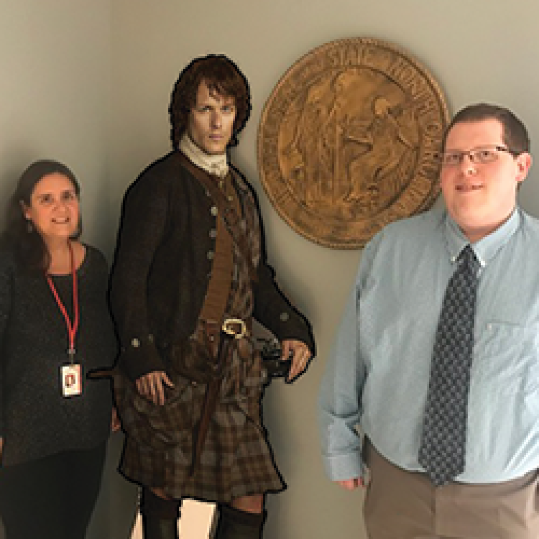 Josh Hager and Alison Thurman stand beside a life-size figure of an Outlander character during a “Documenting the World of Outlander” presentation.
