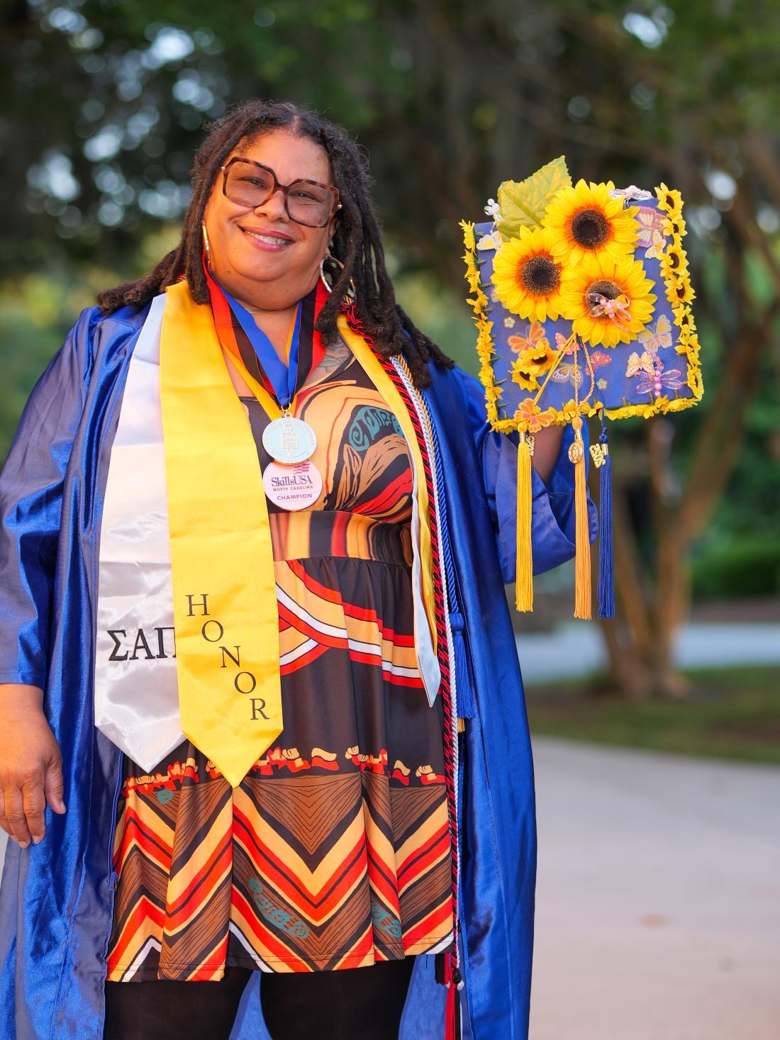 Woman stands in graduation gown