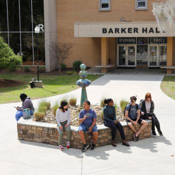 students sitting around outside fountain
