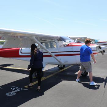 Two aviation students check on two-seater plane