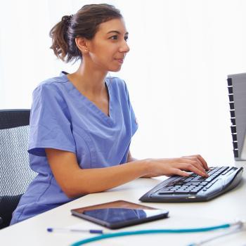 Nurse on a computer while sitting in desk chair