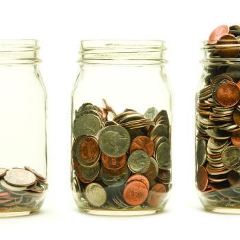 Three glass jars increasingly filled with coins