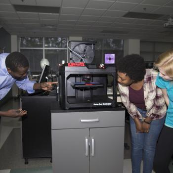 Students looking at 3-D printer