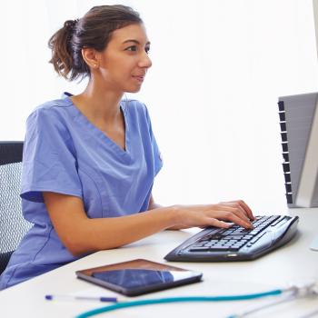 Nurse on a computer while sitting in desk chair