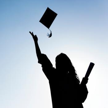 Silhouette of female graduate holding diploma in one hand and tossing grad cap into the air with the other hand