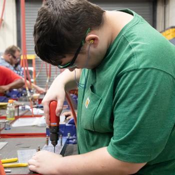 Student in the Advanced Aviation Sheet Metal class uses a drill