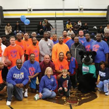 College employees on basketball court with Knight the Panther mascot in 2010s